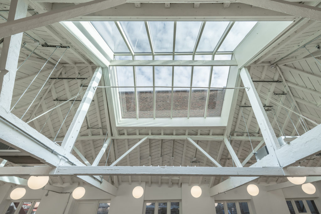 Structural glazed ridge rooflight providing natural daylight within refurbished commercial interior.