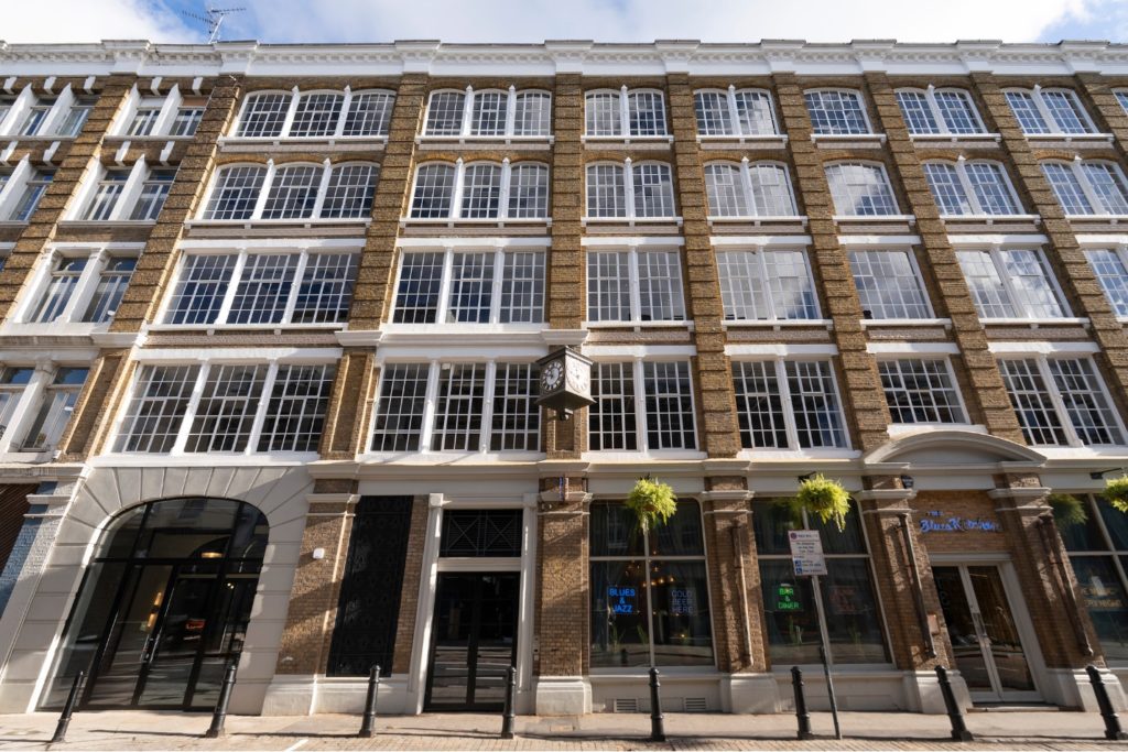 Historic London commercial building exterior with restored brick façade and large industrial windows