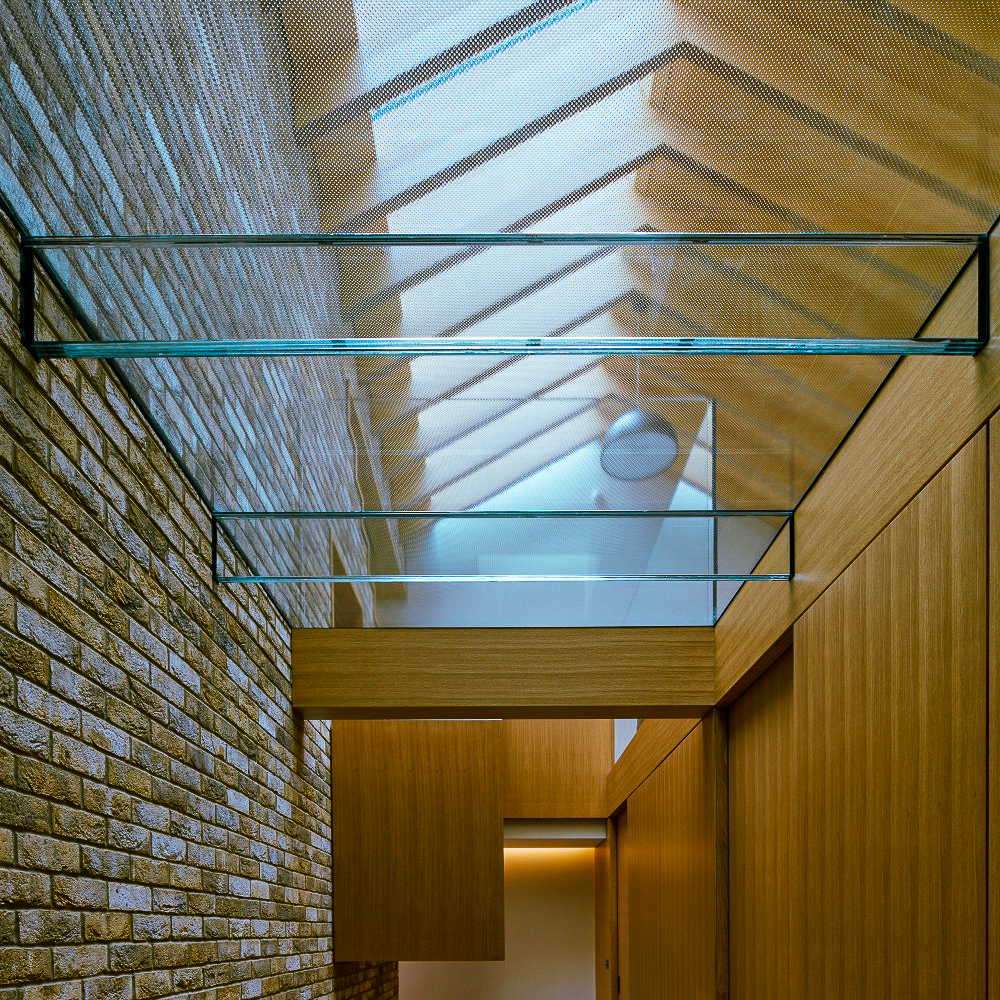 Skylight with wooden beams and brick walls, featuring glass elements and a modern architectural design.