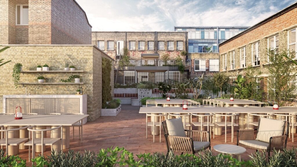 Outdoor courtyard with modern patio furniture, potted plants, and brick walls, featuring bespoke glass boxes, surrounded by buildings and greenery under clear daylight.
